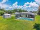 Backyard view with screened pool, storage shed, green grass, sunny weather, with mature trees offering privacy at 909 Hendon Place, Kissimmee, FL 34758