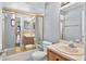 Well-lit bathroom featuring a tub with sliding glass doors and a mirrored vanity at 909 Hendon Place, Kissimmee, FL 34758