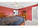 Cozy red bedroom featuring a ceiling fan, lots of dresser storage, and ensuite bathroom at 909 Hendon Place, Kissimmee, FL 34758
