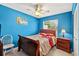 Comfortable bedroom featuring bright blue walls, a ceiling fan, and wood furniture at 909 Hendon Place, Kissimmee, FL 34758