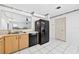 Bright kitchen with wood cabinets, black appliances, and white tiled floors at 909 Hendon Place, Kissimmee, FL 34758