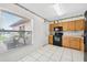 Bright kitchen with white tile floors, wood cabinets, and modern appliances at 909 Hendon Place, Kissimmee, FL 34758