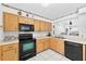 This cozy kitchen features wooden cabinets and black appliances at 909 Hendon Place, Kissimmee, FL 34758