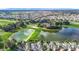 Aerial view of lush community with beautiful homes, scenic lakes, and a picturesque golf course at 1008 Jackson St, The Villages, FL 32162