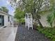 Landscaped backyard with stone ground cover, patio seating, trellis, and a serene outdoor space at 1008 Jackson St, The Villages, FL 32162