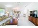 Bright living room with tile flooring, comfortable furniture, and an open layout to the kitchen at 1008 Jackson St, The Villages, FL 32162
