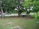 Spacious backyard featuring mature trees and a table for outdoor dining or relaxation at 1021 Golfside Ct, Kissimmee, FL 34741