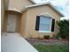 Close-up of a charming house featuring a front door, well-kept lawn, complemented by dark shutters at 1021 Golfside Ct, Kissimmee, FL 34741