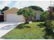 Charming single-story home with a well-manicured lawn, mature landscaping, and a two-car garage at 1021 Golfside Ct, Kissimmee, FL 34741