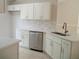 Modern kitchen featuring white cabinets, stainless steel appliances, and a stylish marble backsplash at 1021 Golfside Ct, Kissimmee, FL 34741
