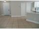 Open living area with neutral walls, tiled floor, and easy access to the kitchen through an open doorway at 1021 Golfside Ct, Kissimmee, FL 34741