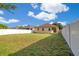 Expansive backyard with green grass and a white fence, ideal for outdoor activities and entertaining at 10580 Moss Rose Way, Orlando, FL 32832