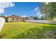 View of the backyard with a lush lawn and a white fence, perfect for relaxation and recreation at 10580 Moss Rose Way, Orlando, FL 32832