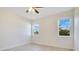 Well-lit bedroom featuring two windows, light flooring, and a ceiling fan at 10580 Moss Rose Way, Orlando, FL 32832