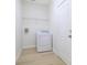 Bright laundry room featuring a white washer and dryer, wire shelving, and light wood-look flooring at 10580 Moss Rose Way, Orlando, FL 32832