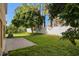 A large green yard featuring mature trees with a patio and a white fence in the background at 1130 Burland Cir, Winter Garden, FL 34787