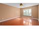 A bedroom featuring hardwood floors, a ceiling fan, and a large sunny window at 1130 Burland Cir, Winter Garden, FL 34787