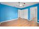 Clean bedroom with a ceiling fan, closet, door, wood floors, and blue walls at 1130 Burland Cir, Winter Garden, FL 34787