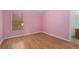 Bedroom features pink walls, wood laminate flooring, with a window for natural light at 1130 Burland Cir, Winter Garden, FL 34787