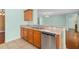 Open kitchen with stainless steel dishwasher and sink and wooden cabinetry at 1130 Burland Cir, Winter Garden, FL 34787