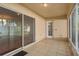 A covered patio with a tiled floor, large sliding glass doors, and a white trimmed doorway at 1130 Burland Cir, Winter Garden, FL 34787