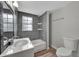 Renovated bathroom with gray tiled shower, white vanity and hardwood-style floors at 1310 Coletta Dr, Orlando, FL 32807