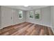 Bright bedroom with wood-look flooring, neutral walls, and natural light from two windows at 1310 Coletta Dr, Orlando, FL 32807