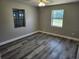 Bedroom featuring wood-look flooring, two windows, and neutral wall color at 13208 Massachusetts Ave, Astatula, FL 34705