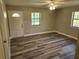 Large bedroom featuring modern wood grain floors, a ceiling fan, and two large windows at 13208 Massachusetts Ave, Astatula, FL 34705