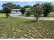 Circular driveway with mature shade trees and lovely pink flowering shrubs at 13208 Massachusetts Ave, Astatula, FL 34705