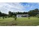 Charming single story home with a large front yard, mature trees, and beautiful landscaping at 13208 Massachusetts Ave, Astatula, FL 34705