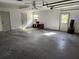 Spacious garage with concrete flooring, multiple access doors, and ample room for parking or storage, adaptable for various uses at 13208 Massachusetts Ave, Astatula, FL 34705