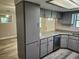 Open kitchen with granite countertops, gray cabinets, stainless steel appliances, and wood grain floors at 13208 Massachusetts Ave, Astatula, FL 34705