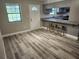 Open concept room with breakfast bar overlooking the kitchen, wood grain floors and a large window at 13208 Massachusetts Ave, Astatula, FL 34705
