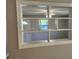 Open-concept living room view featuring a cozy seating area, a bright window, and a stylish interior door at 13208 Massachusetts Ave, Astatula, FL 34705