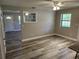 Spacious living room with wood-look flooring, natural light, and a decorative shelving feature at 13208 Massachusetts Ave, Astatula, FL 34705