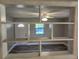 Cozy living room features a view through a pass-through to the entry, modern flooring and a bright ceiling fan at 13208 Massachusetts Ave, Astatula, FL 34705