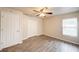 Cozy bedroom featuring ceiling fan, window, closet, and wood-look flooring at 1373 Burnley Ct, Kissimmee, FL 34758