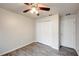 Neutral bedroom with wood-look floors, ceiling fan, closet, and door offers versatile design potential at 1373 Burnley Ct, Kissimmee, FL 34758
