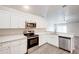 The kitchen features stainless steel appliances and white cabinets with a ceiling fan at 1373 Burnley Ct, Kissimmee, FL 34758