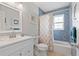 Bathroom with a vanity, blue tiled shower, and bath with a window providing natural light at 141 N Hill Ave # 141, Deland, FL 32724