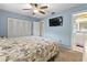 Comfortable bedroom with neutral carpet, white furniture, ceiling fan, closet, and attached bathroom at 141 N Hill Ave # 141, Deland, FL 32724