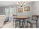 A charming dining area with a round table set, chandelier, and natural light from the nearby window at 141 N Hill Ave # 141, Deland, FL 32724