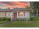 Charming single-story home with red trim, a well-manicured lawn, during a gorgeous sunset at 141 N Hill Ave # 141, Deland, FL 32724