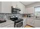 Modern kitchen with stainless steel appliances, granite countertops, stylish backsplash, and white cabinets at 141 N Hill Ave # 141, Deland, FL 32724