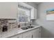 Well-lit kitchen showcasing granite countertops, a mosaic backsplash, and stainless steel sink at 141 N Hill Ave # 141, Deland, FL 32724