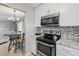 Modern kitchen with stainless steel appliances, granite countertops, and white cabinets at 141 N Hill Ave # 141, Deland, FL 32724