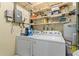 Functional laundry room with a washer, dryer, water heater and ample shelving for storage at 141 N Hill Ave # 141, Deland, FL 32724