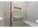 Close-up of the shower with custom tile work, a built-in shelf, and grab bars at 141 N Hill Ave # 141, Deland, FL 32724