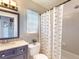 Cozy bathroom with shower-tub combo, neutral tile, and a vanity featuring a decorative mirror at 14529 Falling Tree Ct, Orlando, FL 32837